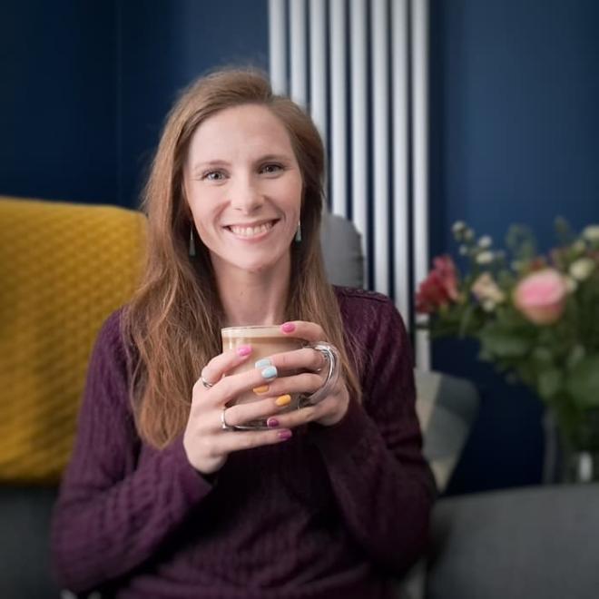 A profile photo of Project Coordinator, Lindsey Cooper, drinking a coffee.