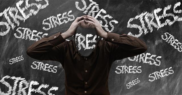 Image of a person with their head in their hands and the word stress in the background.